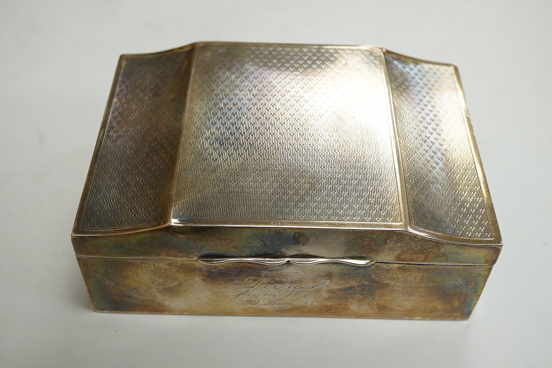 A George V part engine turned silver mounted cigarette box, by Clark & Sewell, with serpentine lid and engraved inscription, Birmingham, 1928, length 12.9cm.